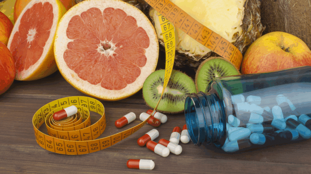 An image of fruits like oranges and kiwi together with supplements and tape measure