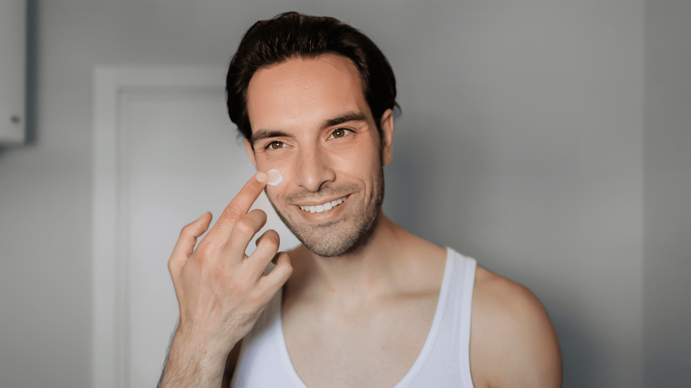 An image of a man applying a facial cream on his face