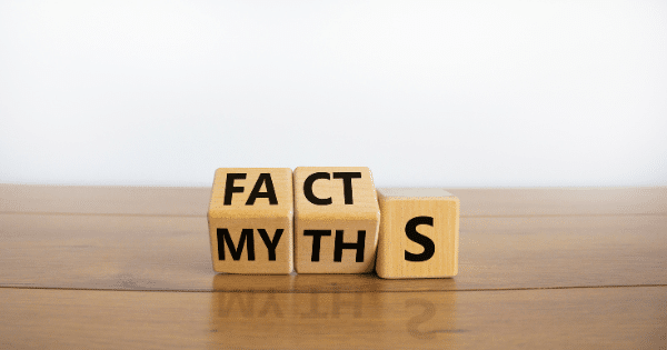 Wooden blocks on a wooden table configured to spell "FACTS" while partially hiding the word "MYTHS".