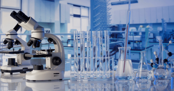 Laboratory setup featuring microscopes, glass test tubes, beakers, and molecular models.