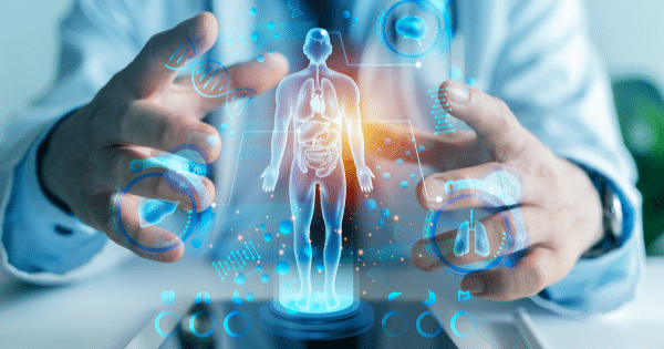 A doctor’s open hands framing a glowing, futuristic 3D holographic projection of a full human body showing internal organs, surrounded by medical charts and DNA helices.