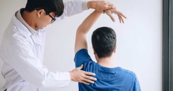 Doctor supporting a patient's arm during a physical examination.