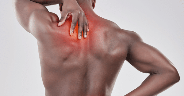 A rear view of a shirtless Black man clutching his upper back and neck, with a red highlighted glow depicting localized muscle soreness or pain.